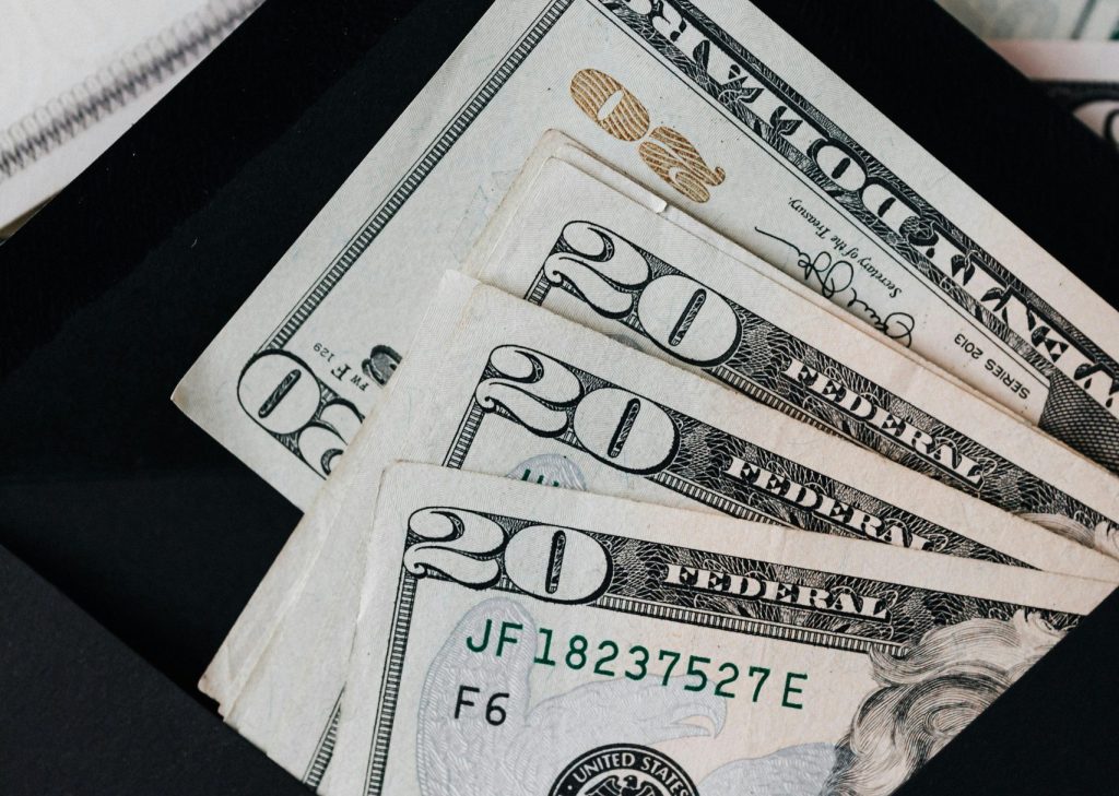Close-up of US dollar bills in a black envelope, symbolizing savings or budgeting.